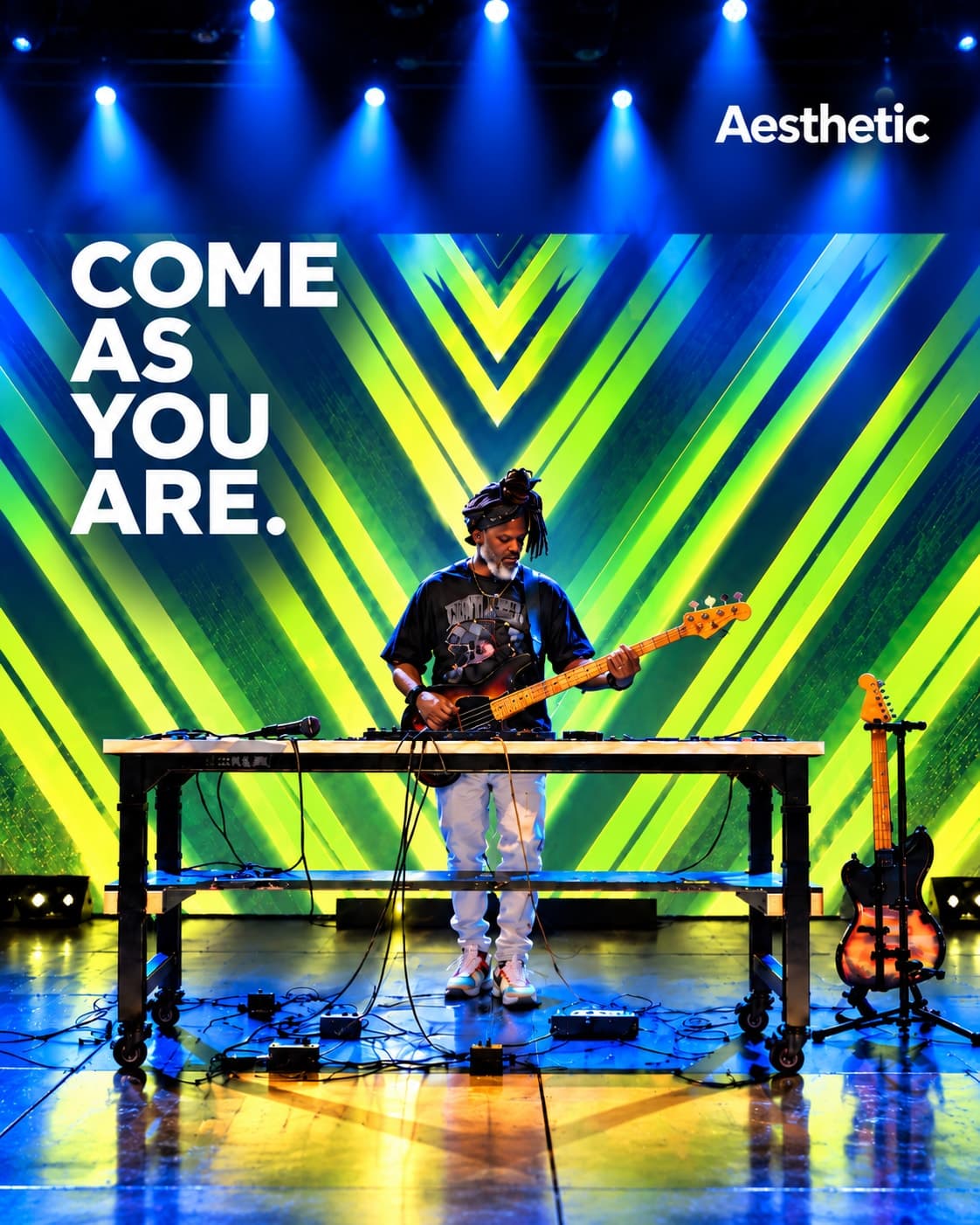 A musician plays bass on stage at a table of pedals, in front of green and yellow chevron projections, beside the words come as you are
